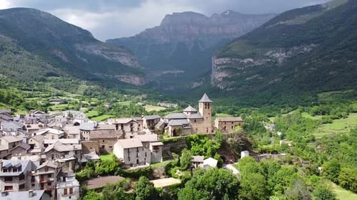 Torla, Ordesa Valley, Huesca, Pyrenees, Spain - Aerial Drone View (Pan Up) of the Church, Green Vall