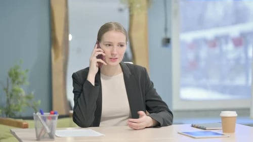 Businesswoman Talking on Phone at Office Desk