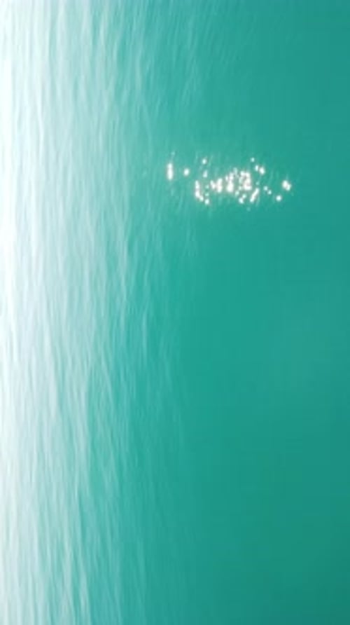 Vertical Aerial View on Sea Water Surface Camera Flies Over Clear Sea Water Sun Glare Abstract