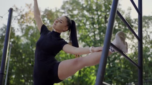 Young Woman Performing Outdoor Stretching Exercises in Park