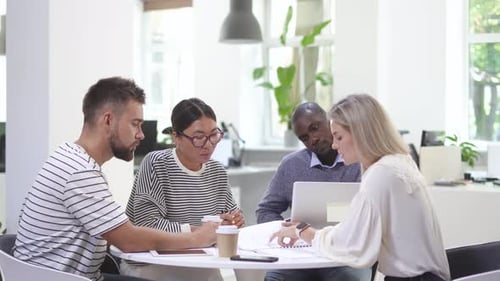 Diverse Team Collaborating on Project in Modern Office
