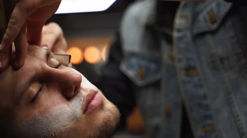 Man Having Straight Razor Shave at Barber Shop