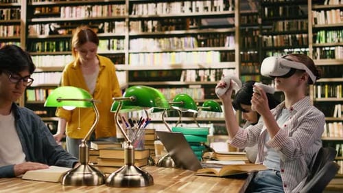 Student Using Virtual Reality Headset and Hand Controllers at Library Desk