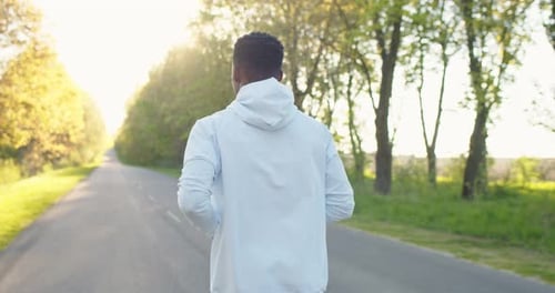 Back View of Young African American Handsome Male Athlete Jogging Outdoors Alone on Street Young Fit
