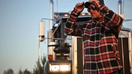 Caucasian Professional Trucker in Front of His Truck
