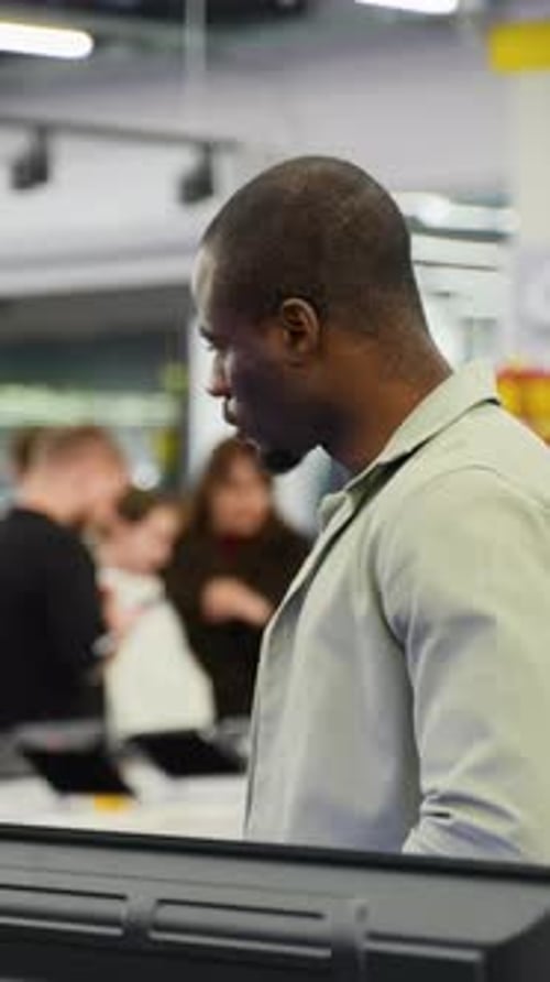 Customer Evaluating Electronics in Retail Store with Discount