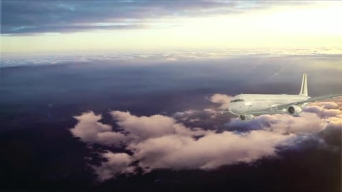 Commercial Airplane Flying Above Clouds at Golden Hour