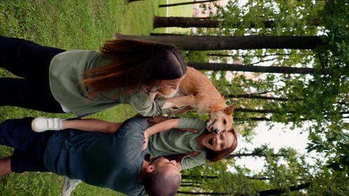 vertical video happy young family in park with dog dad holding daughter in arms concept trust care