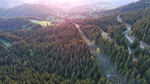 Lift with Cable Passes Between Spruce Forest on Peak Against Backdrop of Mountain Ranges of Rhodope