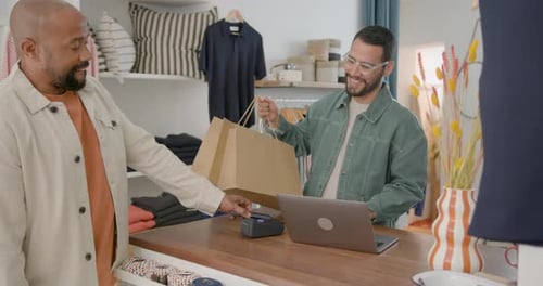 Customer making contactless payment at clothing store