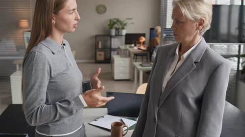 Businesswomen Talking and Shaking Hands in Modern Office