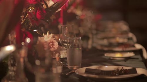 Close up to elegant glasses and plates placed on a table at a wedding reception