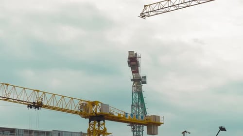 Many tower cranes work on construction site. They move and build building.