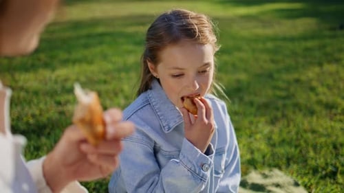 Happy Girl Eating Snack Outdoors in Green Park