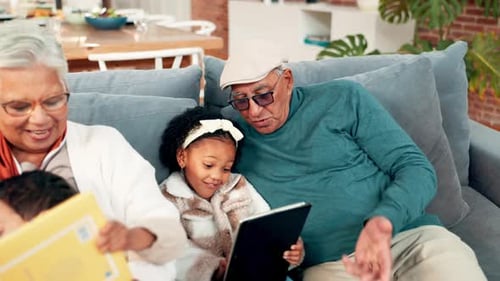 Grandparents with Grandchildren Reading Book and Using Tablet