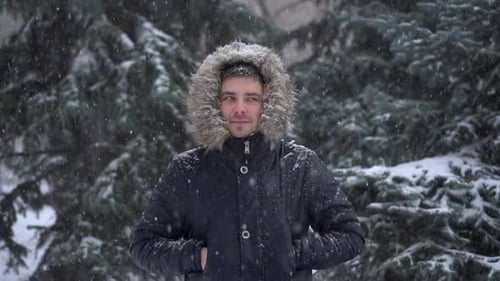 Young Man Standing in Gentle Winter Snowfall