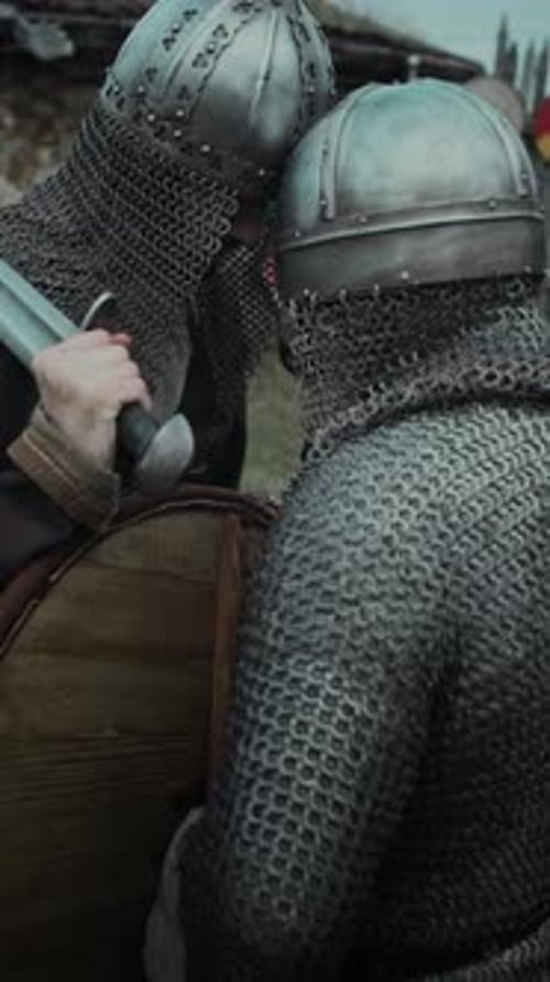 Zwei Ritter in Kettenhemd und Helm berühren sich vor dem Kampf ihre Köpfe