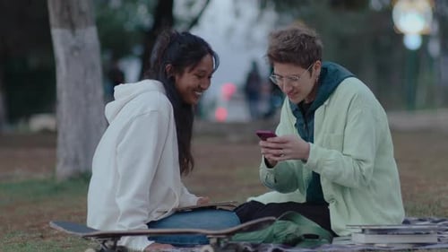 College Girls Using Phone and Chatting in the Park