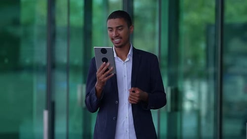 A Professional Man Using a Tablet in a Contemporary Office Environment to Enhance Work