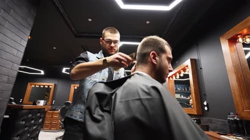 Barber Trims Hair in Modern Barbershop