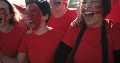 Excited women sports fans cheer in red