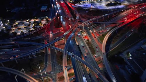 Transport with headlights on riding by the intertwining motorways.