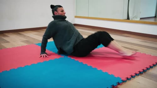 Premiers exercices d'échauffement physique avant de danser sur le tatami bleu et rouge