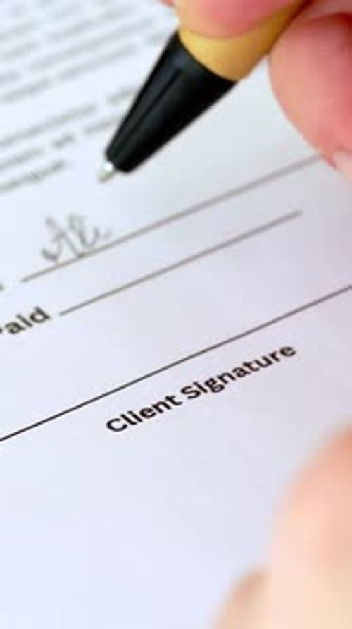 Closeup Shot of Young Woman with Pen Signing Contract