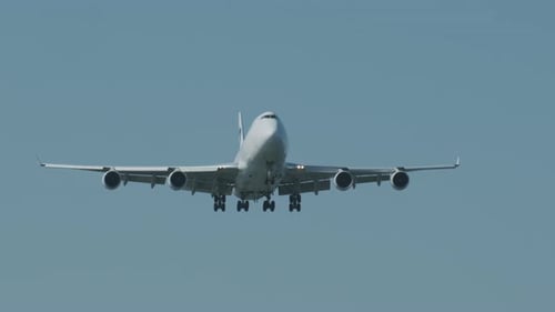 Airplane flying against clear blue sky during daytime
