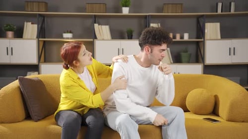 Woman Comforts Distressed Man on Couch