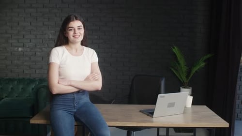 Confident Young Woman Leaning in Modern Office