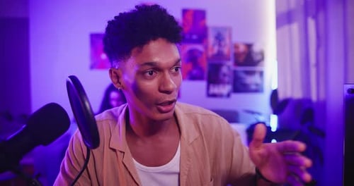 Young Adult Talking To Camera At Home