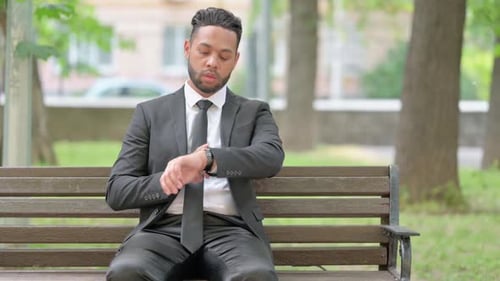 Man in Suit Waits on Park Bench