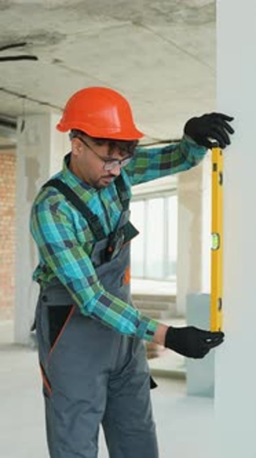 Construction Worker Checking Vertical Alignment with Spirit Level