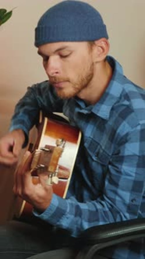 Young Adult Plays Guitar at Home