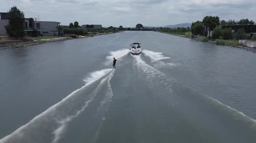 Luftaufnahme einer Wakeboard-Sportboot-Übung auf dem See mit ruhigem Wasser