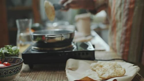 Close-Up of Serving Freshly Fried Indian Puris on Plate in Kitchen