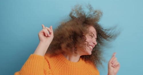 Happy Woman with Curly Hair Dances Energetically