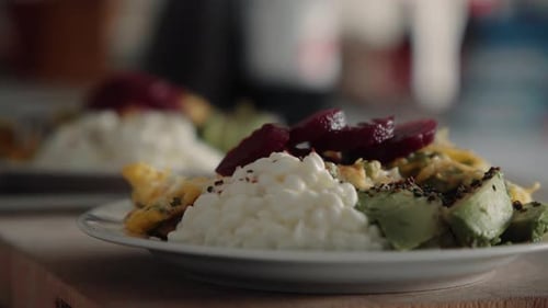 Woman taking her Healthy high protein lunch ( Beetroot Eggs Avocade) from a wooden cutting board