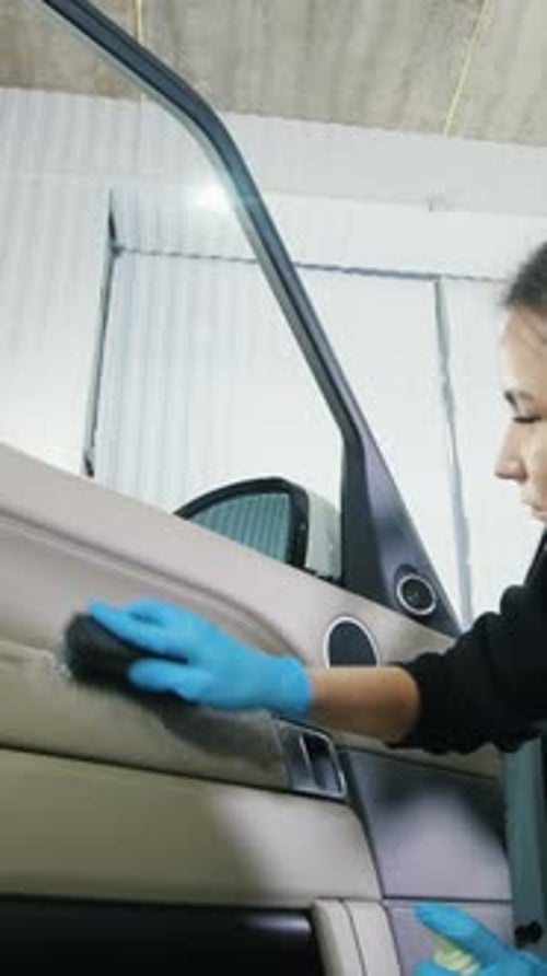 Woman Detailing Car Interior in a Garage Setting