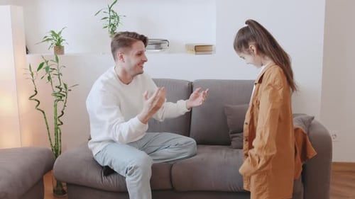 Loving Father Helping Young Girl with Jacket in Home