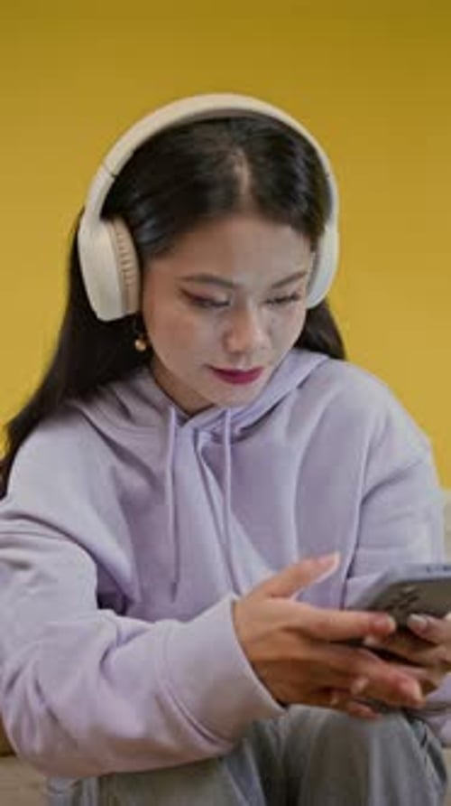 Young Woman Listens to Music with Headphones