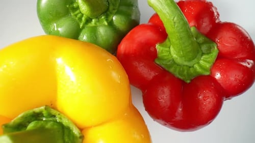 The macro video featuring succulent green, fiery red, and sunny yellow bell peppers