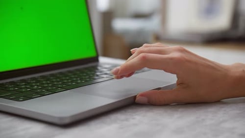 Closeup of Hand Using Laptop Touchpad with Green Screen