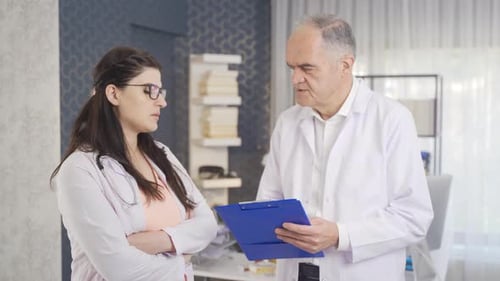 Doctors Discussing Patient Notes in Hospital Office