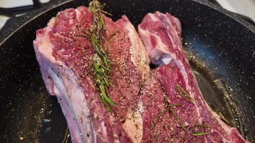 Seasoned Raw Beef Steaks with Rosemary in Pan