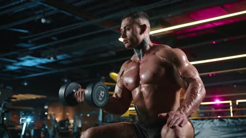 Ein muskulöser Mann wird im Fitnessstudio beim Hantelheben gesehen, der sich auf das Bodybuilding-Training konzentriert