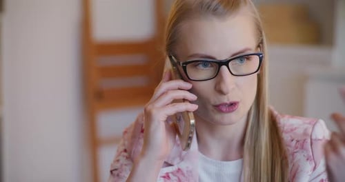 Serious Woman Talking on Smartphone Indoors