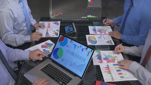 Businessman and woman discussing on stock market charts in office,