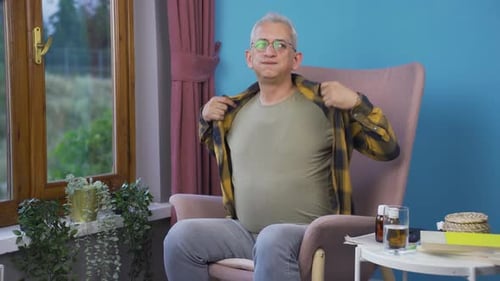 Man Sitting in Chair with Possible Health Issues